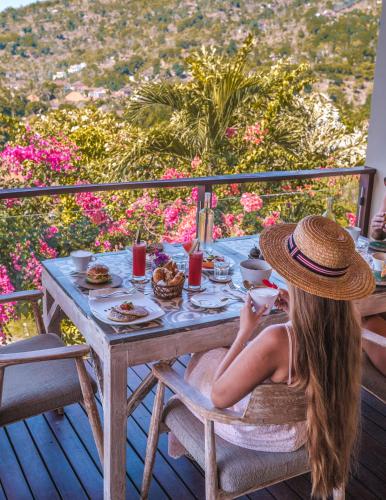 a woman sitting at a table with food on it at The Griya Villas and Spa in Amed