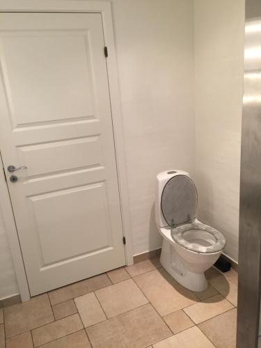 HarlevにあるStenbrogårdの白いドアとトイレ付きのバスルーム