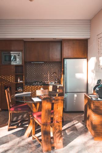 a kitchen with a table and a refrigerator at The Griya Villas and Spa in Amed