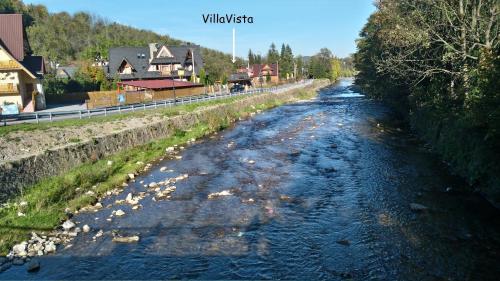 um rio com pedras ao lado dele em Villa Vista Apartamenty & SAUNA em Zakopane