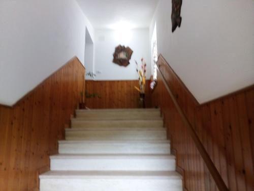 a staircase in a building with white stairs and wooden floors at B&B ca'del grillo in Castel del Rio