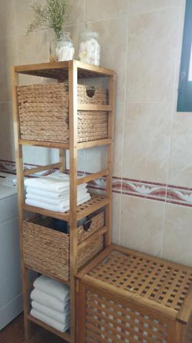 a wooden shelf with towels and baskets in a bathroom at Casa Blas in Puerto del Rosario