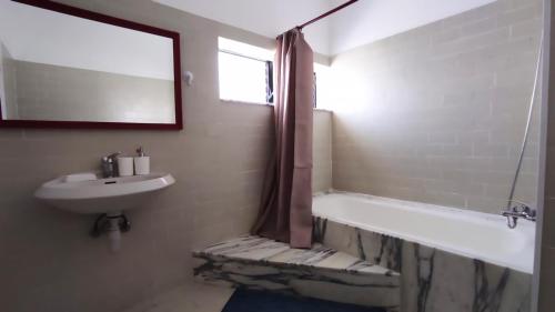 a bathroom with a tub and a sink and a mirror at Guest House "Villa Klara Eilat" Heated pool and sauna all year round in Eilat