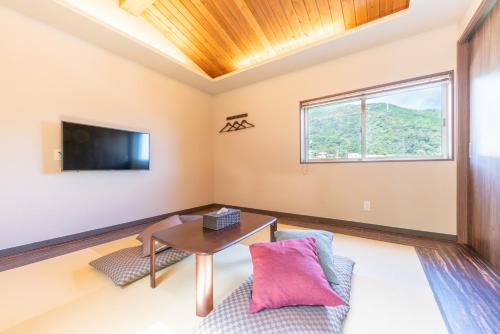 een woonkamer met een tafel en een televisie bij 郷隅美悦 - Kyo Gu Bi Etsu in Hakone