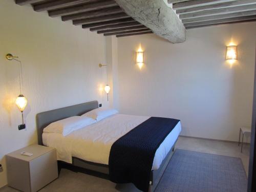 a bedroom with a bed and two lights on the wall at Podere La Casa in Villa dʼArceno
