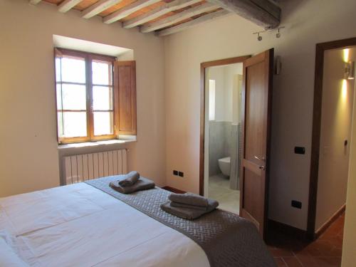 a bedroom with a large bed and a bathroom at Podere La Casa in Villa dʼArceno