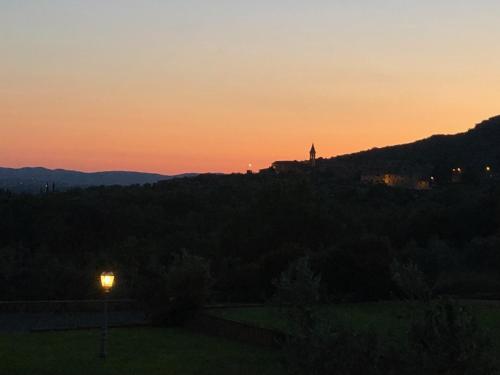 a sunset with a building on a hill with a street light at Podere La Casa in Villa dʼArceno