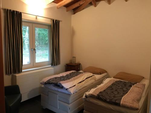 2 łóżka pojedyncze w pokoju z oknem w obiekcie Het Atelier, ruime vrijstaande vakantiewoning 200m2 voor maximaal 8 personen w mieście Leende