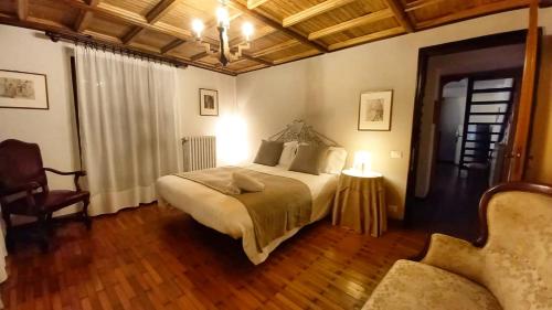 1 dormitorio con 1 cama, 1 silla y 1 sofá en Chalet nelle vigne, en Novello