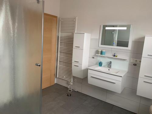 a white bathroom with a sink and a shower at Zur Vogelwiese in Bresewitz