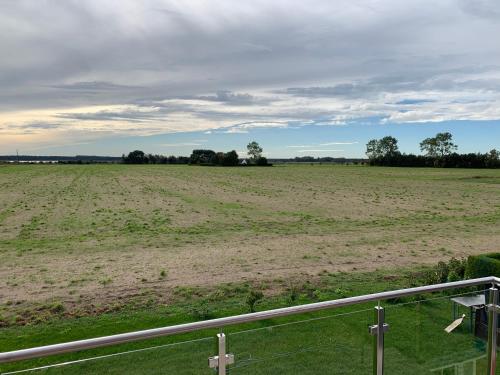 una vista de un campo con una valla y una cruz en Zur Vogelwiese, en Bresewitz