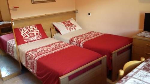 a room with two beds with red and white covers at Casa Norberto in Livigno