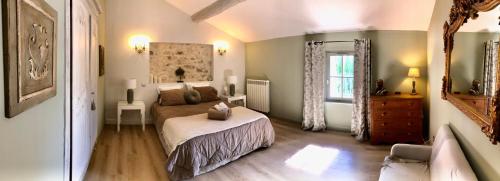 a bedroom with a bed and a couch and a window at La Bri...Gite in LʼIsle-sur-la-Sorgue