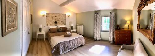 um quarto com uma cama, um sofá e uma janela em La Bri...Gite em LʼIsle-sur-la-Sorgue