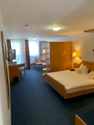 a hotel room with a bed and a desk at Hotel Sonnenhof in Bad Wildbad