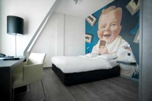 a room with a bed and a painting of a baby at Inntel Hotels Amsterdam Zaandam in Zaandam