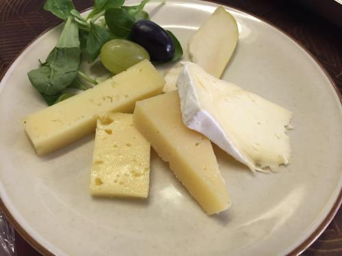 a white plate with cheese and other foods on it at Hotel Fonte dei Fiori in Caslano