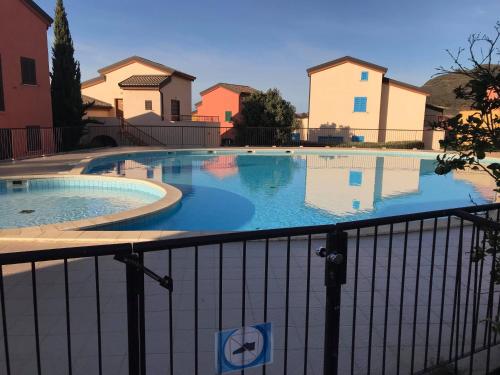 une piscine avec une clôture et des maisons dans l'établissement Appartement Dolce Farniente Corse Lozari, à Belgodère