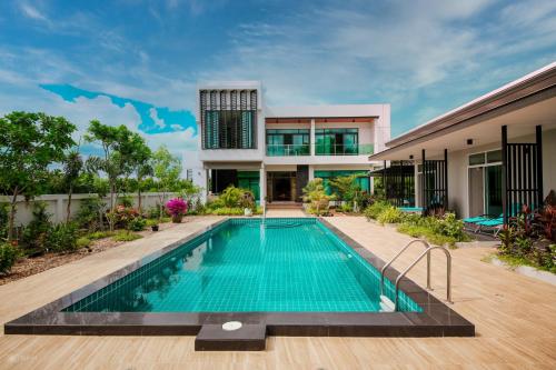 a swimming pool in front of a house at Lotus Lake View in Ban Bua