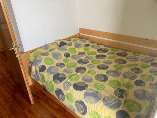 ein Bett mit einer Daunendecke mit Muscheln drauf in der Unterkunft Apartma Ajdovka Rogla in Vitanje