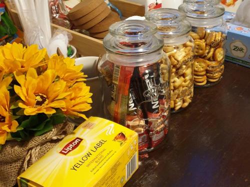 a table with jars of candy and flowers and a box at ฮักเคียงโขง HUG Khieng Khong Nongkhai Hostel in Nong Khai