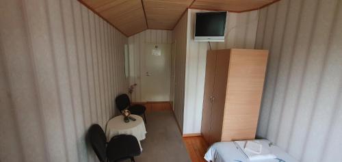 Rahinge的住宿－庫爾旅館，小房间设有桌椅和电视