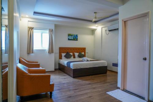 a bedroom with a bed and a chair at Suraksha Stay ITPL Hotel Banglore in Bengaluru