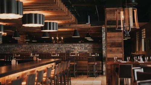 a restaurant with a bar and tables and chairs at Trail Creek: Walk to lifts, ski home! Closest unit to lifts, ski home trail, sports center in Killington