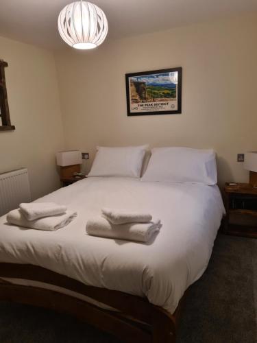 1 dormitorio con 1 cama grande y toallas. en Derwentwater Arms en Curbar