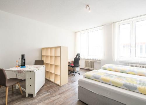a bedroom with a bed and a desk in it at Apartmenthaus Aalen in Aalen