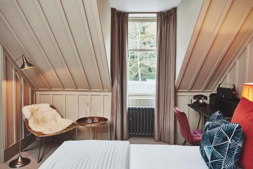 a bedroom with a bed and a window and a chair at No.26 By The Sea in Oban