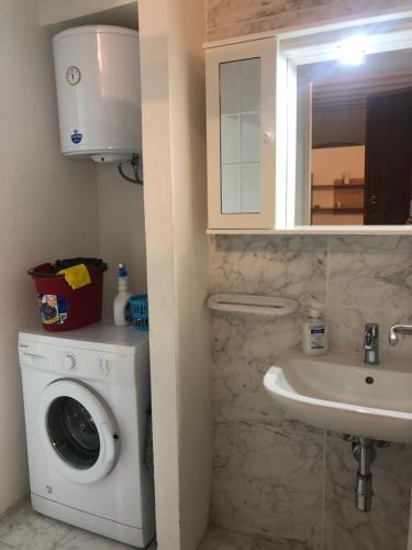 a bathroom with a washing machine and a sink at Casa Francesca in Carloforte