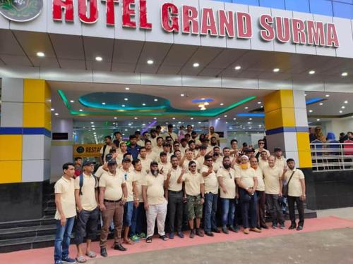 a large group of people standing in front of a building at Grand Surma Hotel in Sylhet