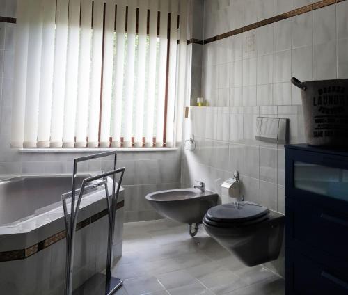 a bathroom with a tub and a toilet and a sink at An den Auwiesen in Kleineicholzheim