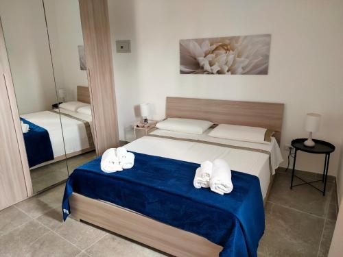 sypialnia z łóżkiem z ręcznikami w obiekcie Case Carancino Giove w Syrakuzach