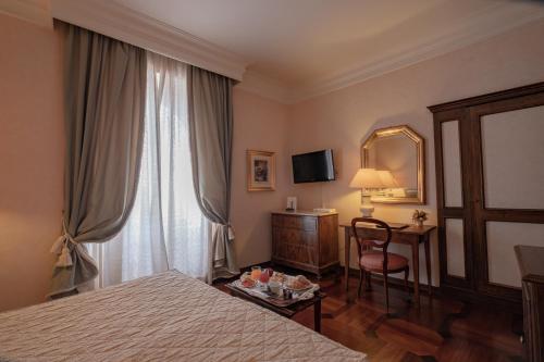 a bedroom with a bed and a television at Relais Ducale in Gubbio