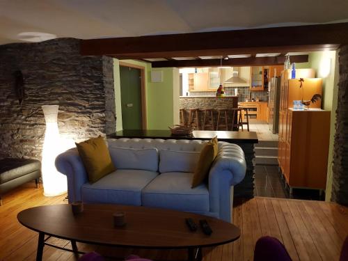 ein Wohnzimmer mit einem blauen Sofa und einer Küche in der Unterkunft Espace Cosmos in Vaux-sur-Sûre