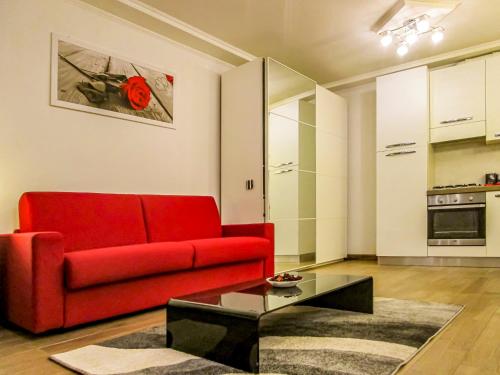 Sala de estar con sofá rojo y mesa de centro en La Piccola Corte, en Trieste