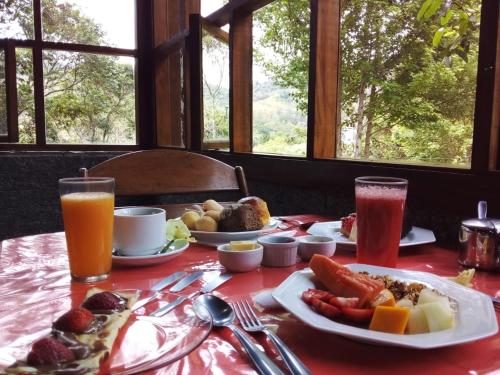 a table with plates of food and drinks on it at Pousada Alpes in Santo Antônio do Pinhal
