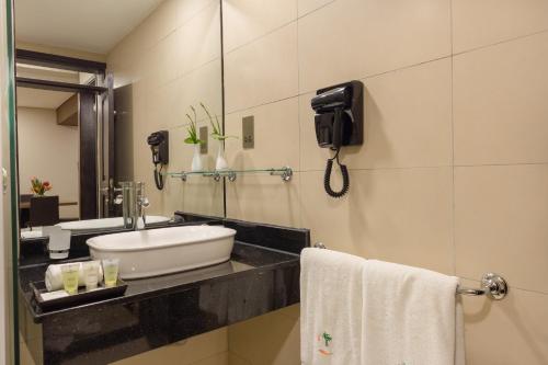 a bathroom with a sink and a phone on the wall at Kabira Country Club in Kampala