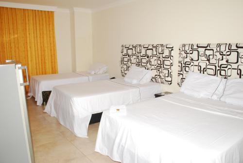 a room with two beds with white sheets at KALINA HOTEL in Girardot