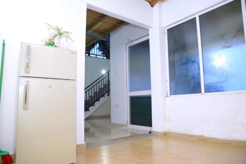 an empty room with a refrigerator and a staircase at White house in Nuwara Eliya