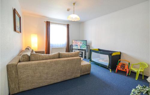 ein Wohnzimmer mit einem Sofa und einem Kinderbett in der Unterkunft Lovely Apartment In Wusterhusen With Wifi in Wusterhusen