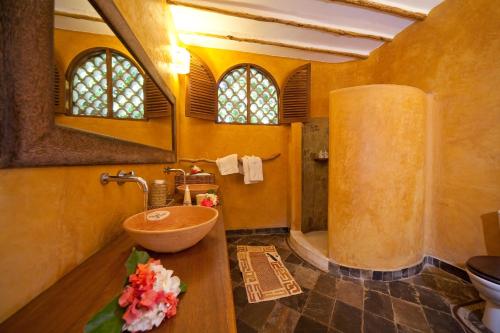 een badkamer met een houten wastafel en een bad bij Waterlovers Beach Resort in Diani Beach