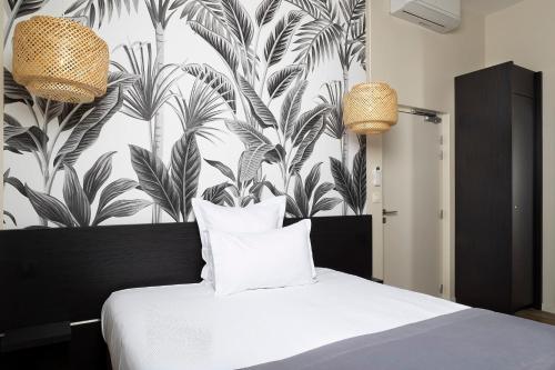 a bedroom with a bed with a black and white wallpaper at La Sorelle Hôtel Golf et Restaurant in Villette-sur-ain