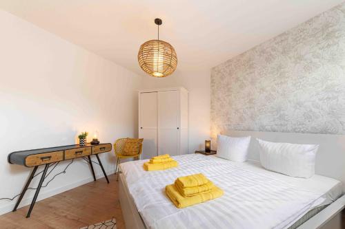 a bedroom with a bed with yellow towels on it at Apartment Elbkiez - Wohnen zwischen Elbe & Altstadt, stilvoll mit Balkon! in Dresden