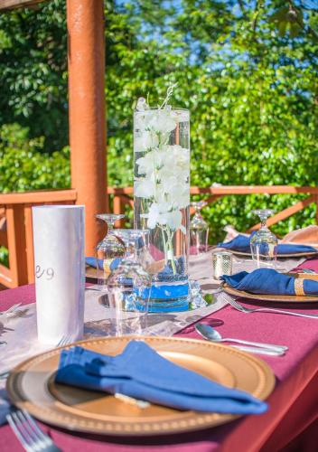 a table with a purple table cloth with plates and a vase at Bay View Eco Resort & Spa in Port Antonio