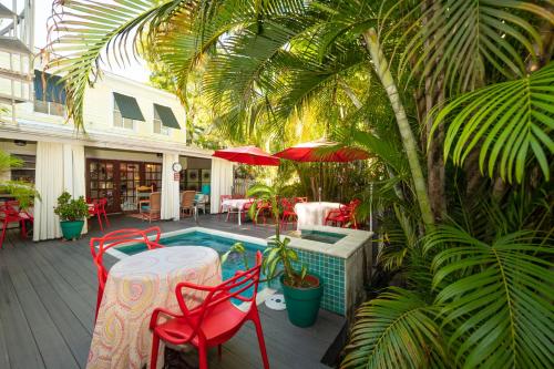 a patio area with tables, chairs and umbrellas at Knowles House B&B - Adult Only in Key West