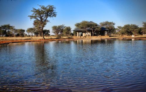 a large lake with a gazebo in the background at Africa Awaits Lodge & Safaris in Gobabis