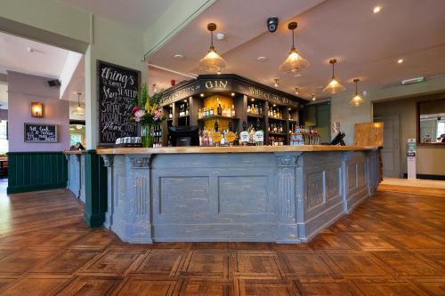 a bar in a pub with a blue counter at Worplesdon Place Hotel in Guildford